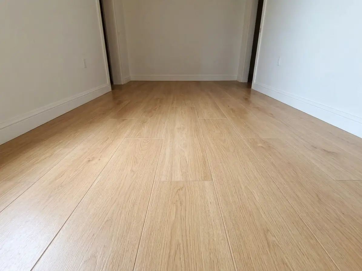 La même pièce sous le même angle : sol refait en carrelage imitation chêne clair posé à joints décalés.